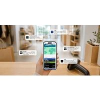 Ruka držící smartphone s digitálními věrnostními kartami v Apple Wallet na pozadí prodejny s notifikacemi značek.